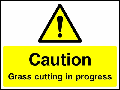 A black exclamation mark inside a yellow warning triangle above black wording on a yellow panel with Caution — Grass cutting in progress wording. CONS0099 artwork.