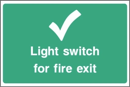 Light switch for fire exit sign showing tick symbol and switch identification. Artwork EMER0097.