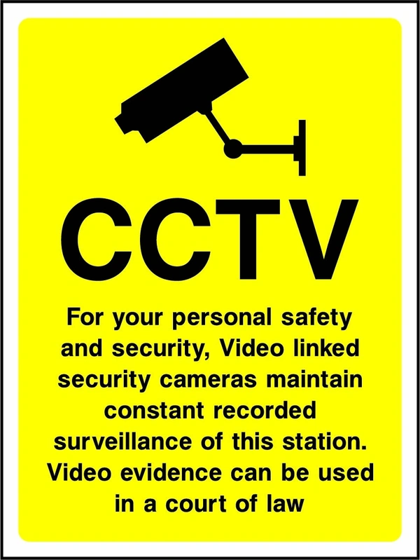 CCTV — Video linked security cameras maintain constant recorded surveillance of this station sign. black CCTV camera pictogram and wording on a yellow panel. Artwork SECU0010.